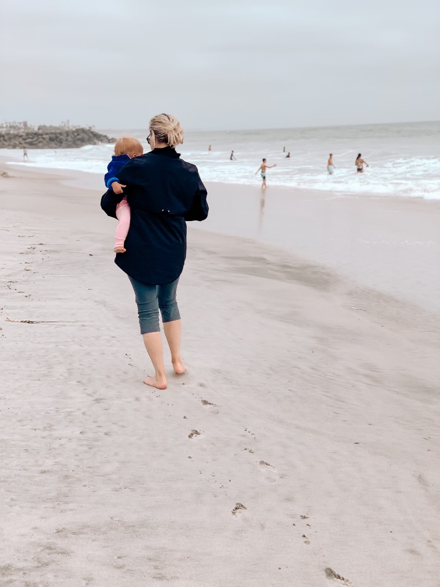 Jane holding granddaughter on a beach